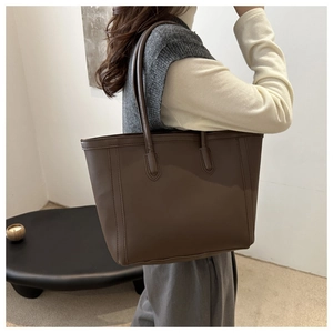 Detail view of brown PU leather tote bag showing large capacity and minimalist stitching