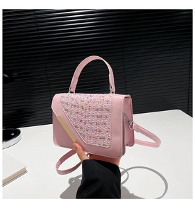 Détail d'un sac en cuir rose avec rabat en tweed multicolore et plaque en métal doré