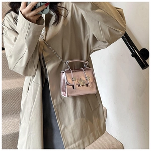 Model showing metallic pink mini bag with star buckle and chain strap on shoulder