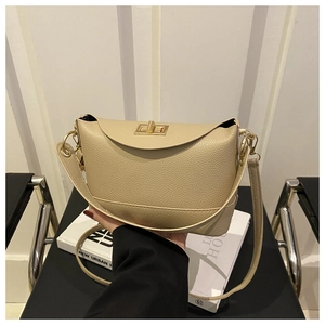 Détail du sac seau en cuir grainé beige avec fermoir métallique doré élégant