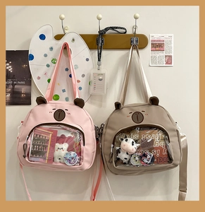 Detail of cute canvas tote bag with transparent PVC window and bear embroidery