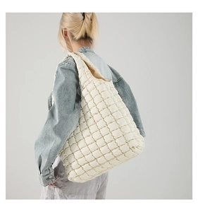 Detailed close-up of a large beige quilted bubble hobo bag showing popcorn texture detail