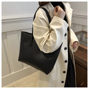 Classic large black matte leather tote bag worn by model for daily office commute