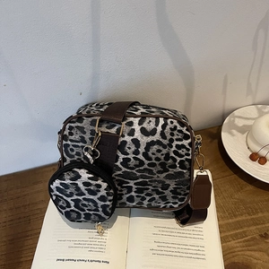 Stylish leopard print crossbody bag with detachable round coin purse on a wooden desk