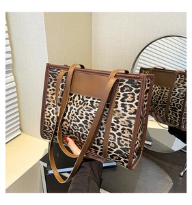 Gros plan du sac fourre-tout léopard avec anses en cuir brun et design spacieux