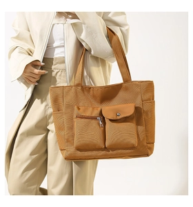 Detail view of large nylon tote bag with functional pockets and premium silver hardware