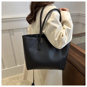 Detail view of large black matte leather tote bag with long shoulder straps for work