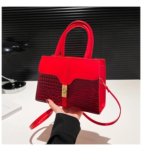 Detail showing red leather handbag with crocodile pattern and golden square clasp