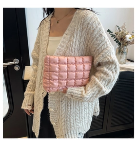 Pochette rosa trapuntata in un ambiente elegante con libri e decorazioni floreali