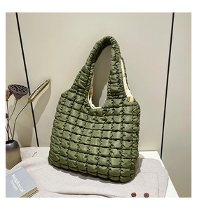 Detail of dark green puffer shoulder bag with quilted texture and soft nylon finish