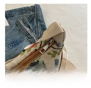 Detail of a smooth silver zipper closure on a vintage floral jacquard canvas shoulder bag