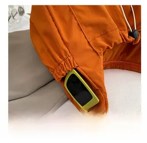 Close-up of the functional side pocket on the orange nylon bag with sunglasses storage
