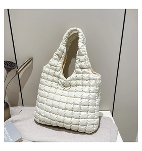 Detail of white quilted bubble tote bag showing soft puffy texture and grid pattern
