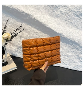 Dettaglio della borsa per cosmetici in pelle PU marrone trapuntata con texture 3D cubica