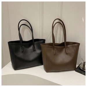 Detail view of black and brown leather tote bags with long shoulder straps for daily commute