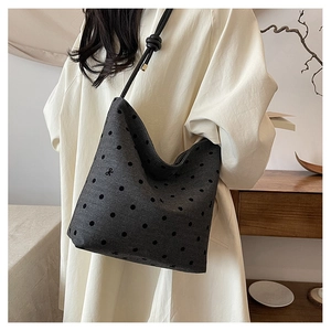 Detail of dark grey canvas tote with black polka dots and delicate bow embroidery