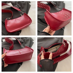 Détail du sac sous l'aisselle en cuir rouge avec rivets argentés et bandoulière