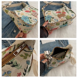 Detail of floral canvas shoulder bag showing reinforced leather edges and metal zipper hardware