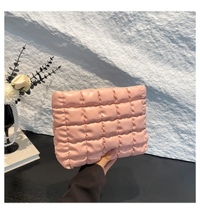 Dettaglio della borsa cosmetica rosa trapuntata con finitura lucida e trama morbida
