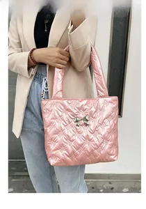 Gedetailleerd beeld van de roze gewatteerde shopper met zilveren strik bij een model
