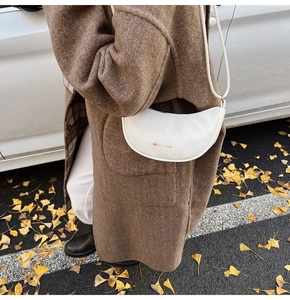 Detail of white crescent moon bag with golden FASHION & BAGS logo on leather