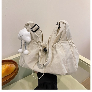 Detail of solid nylon hobo bag with adjustable strap and plush cloud charm
