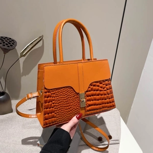 Orange croc-embossed leather handbag with gold twist lock and adjustable shoulder strap