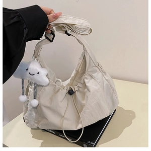 Detail of nylon hobo bag with drawstring texture and cute cloud plush charm