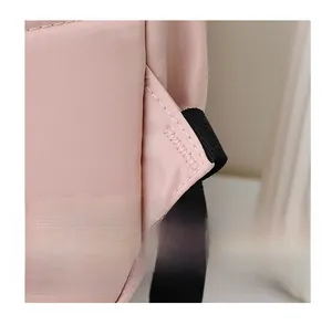 Close-up of reinforced triangle stitching and pink nylon fabric texture on a backpack