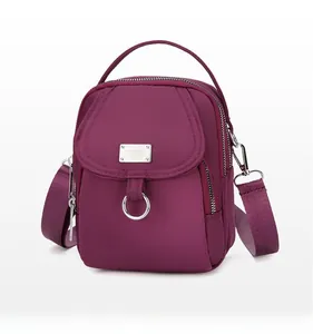 Detailed side view of dark plum purple crossbody phone bag with multi-zipper compartments