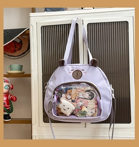 Detail of light purple ita bag with a transparent window and cute bear ears decoration