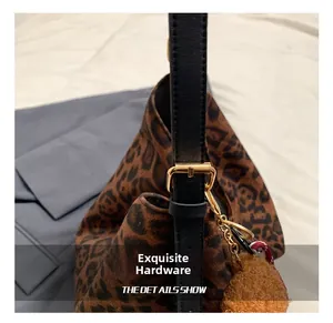 Close-up of leopard print tote bag with golden metal buckle and black leather strap