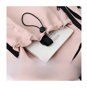Close-up of pink nylon backpack featuring front zipper pocket and drawstring detail