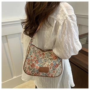 Detail of vintage floral jacquard fabric with premium brown leather trim on shoulder bag