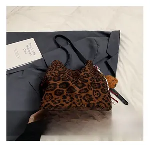 Close-up of leopard print tote bag with soft texture and cute brown bear charm
