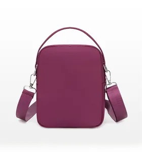 Rear view of purple vertical nylon phone bag with top handle and detachable strap