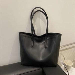 Minimalist black tote bag in vintage faux leather with spacious interior and long handles