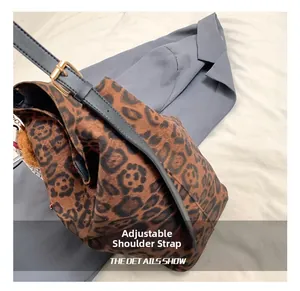 Detail of leopard print tote bag featuring an adjustable black leather shoulder strap