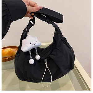 Close-up of black nylon hobo bag with drawstring detail and cute plush cloud charm