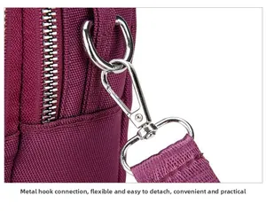 Close-up of durable silver metal hook and woven strap on burgundy nylon crossbody bag