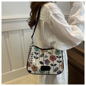 Detail of floral tapestry shoulder bag with adjustable strap shown on model side view