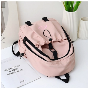 Detail view of pink nylon school backpack with drawstring pocket and black zip closures