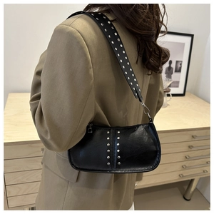 Détail du sac rétro noir à bandoulière avec rivets argentés et texture cuir premium