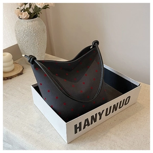Detailed view of grey felt tote bag with large red polka dots in a white display box