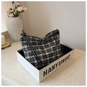 Detail of checkered canvas tote bag with bear embroidery in a stylish gift box