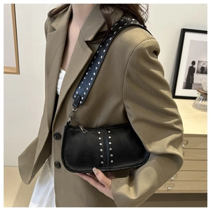 Détail du sac bandoulière en cuir noir avec rivets métalliques et texture lychee