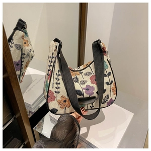 Close-up of knit tote bag featuring colorful abstract floral patterns and a black strap
