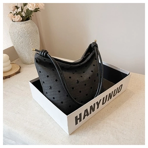 Detailed view of the polka dot canvas hobo bag with bow embroidery in a gift display box
