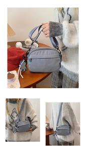 Detail of blue nylon square crossbody bag with adjustable strap and bear charm