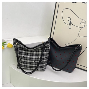 Close-up of stylish canvas tote bags with polka dots and checks on white display stand